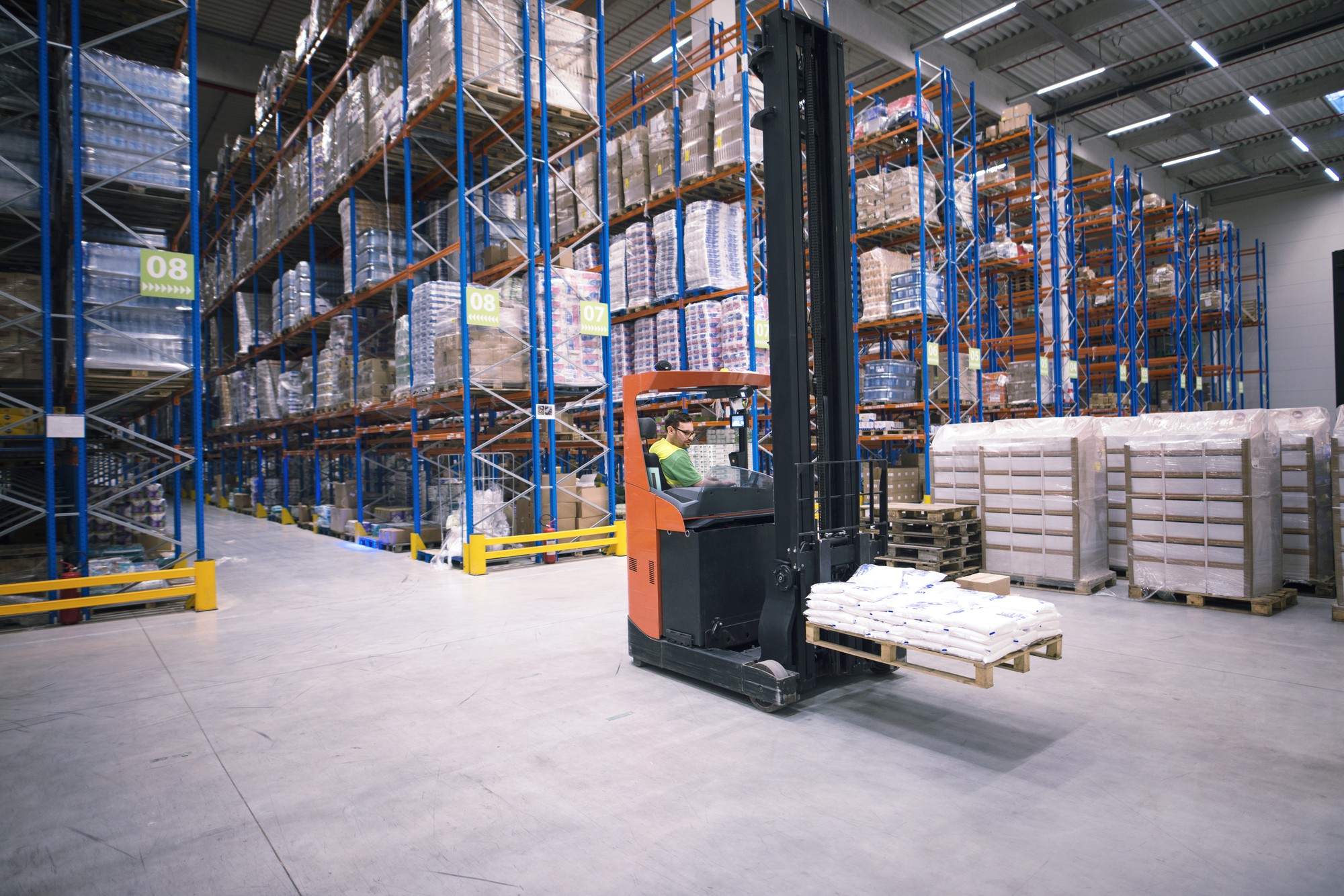 Cariste déplaçant des marchandises dans un grand entrepôt
